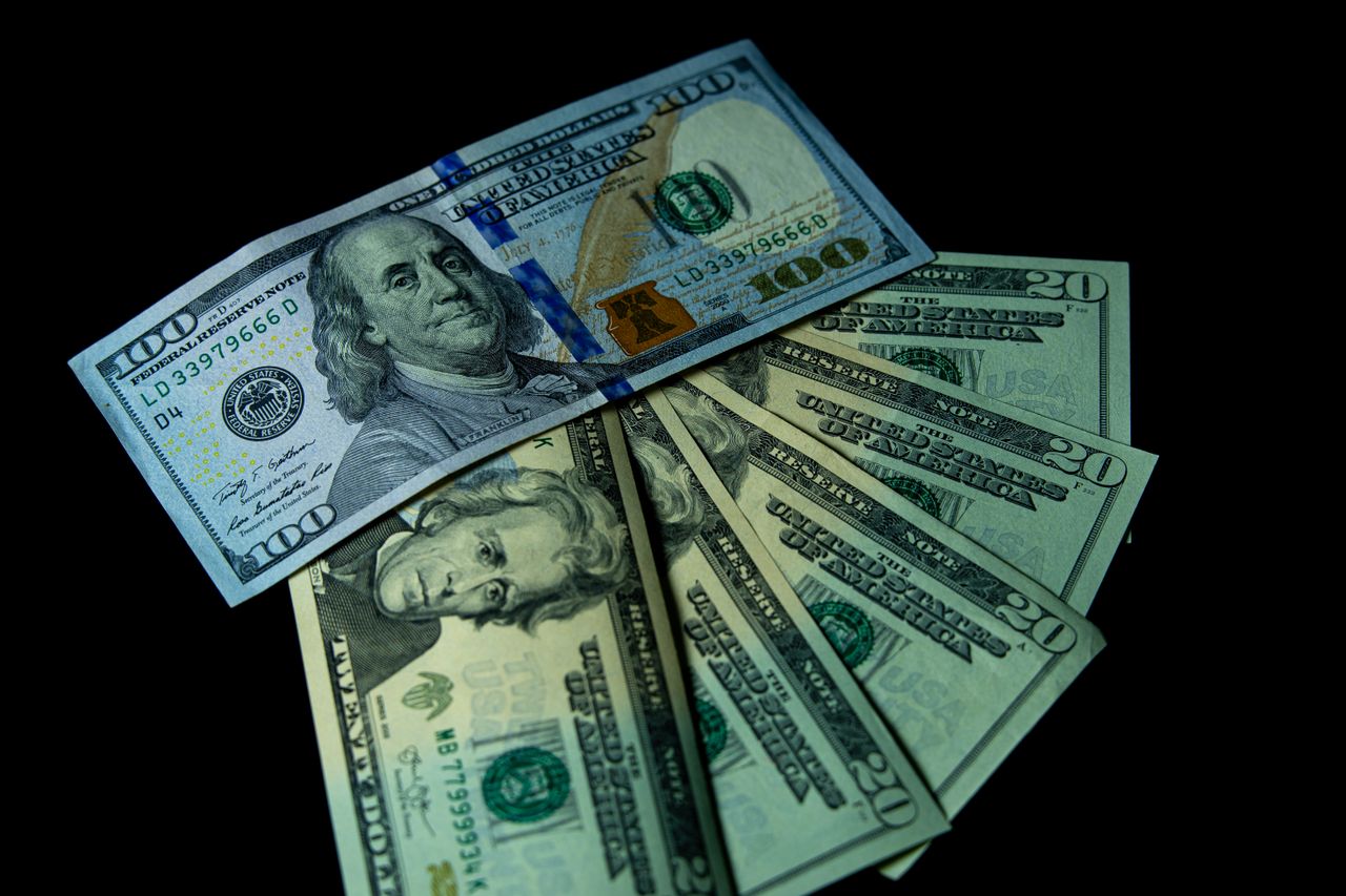 Close-up image of varied US dollar bills on a black background.